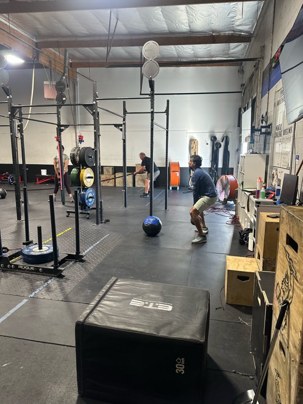 Members working through a class at the pull-up rig with medicine balls.