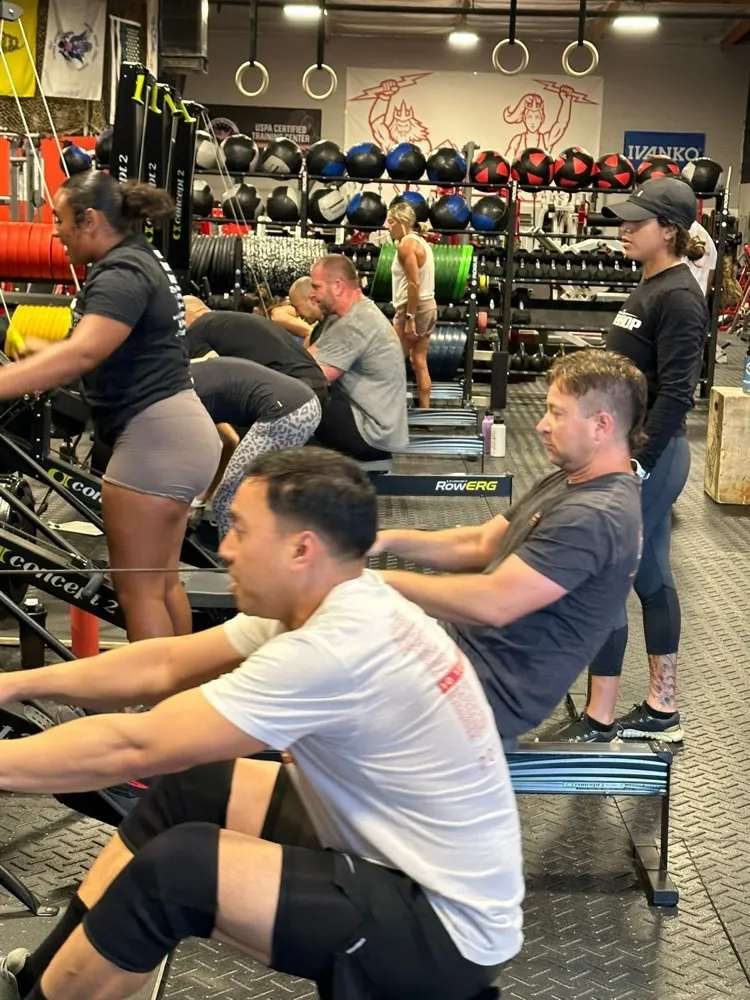 A coach watching members row during a class at PowerSource.