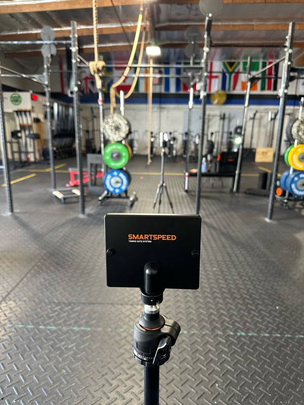 A sprint timing gate set up on the gym floor.